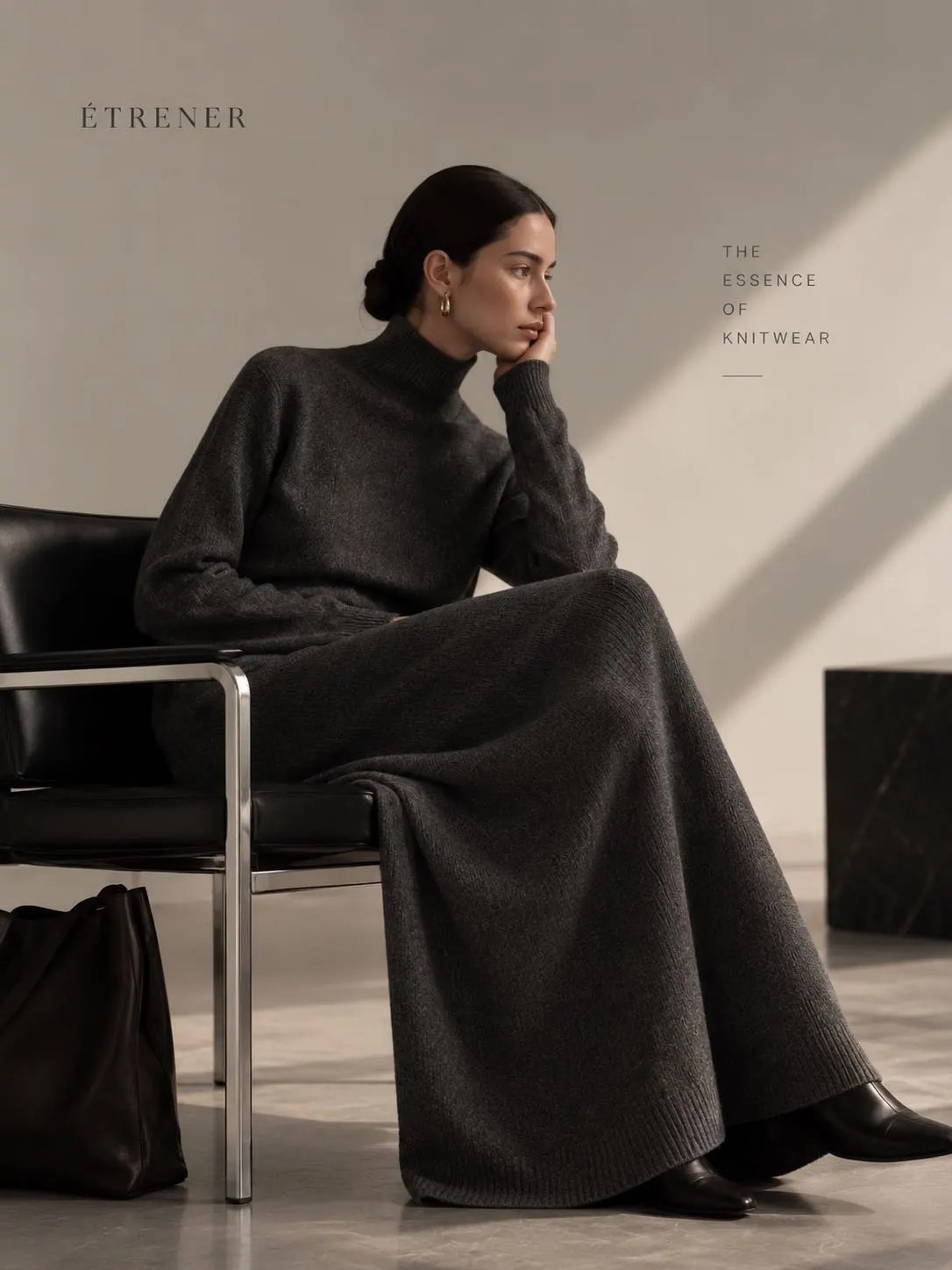 Woman wearing a charcoal grey pleated knit A-line skirt and matching turtleneck sweater by EtrenerKnit